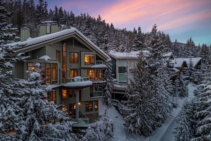 Osprey Chalet in Whistler, BC during winter, surrounded by snow-covered pine trees.
