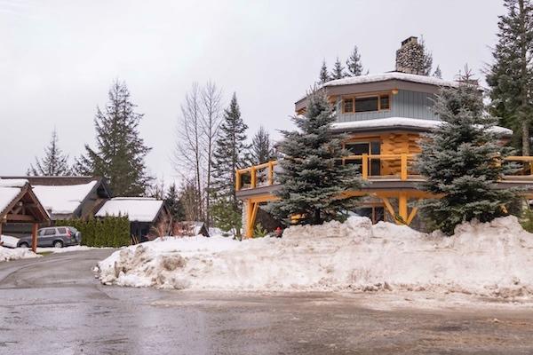 Snowridge Chalet ski-in/ski-out rental in Whistler Creekside with a snow-covered wraparound deck and surrounding evergreen trees